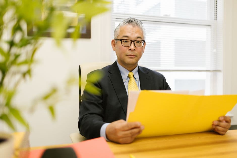 書類を手に持ち確認している男性